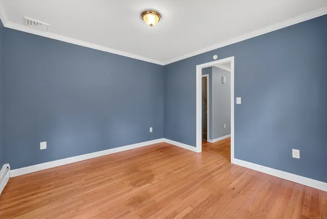 a view of an empty room with wooden floor