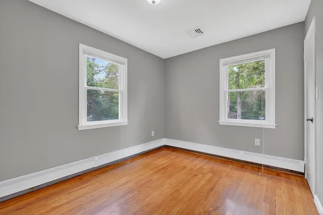 a view of a room with wooden floor and window