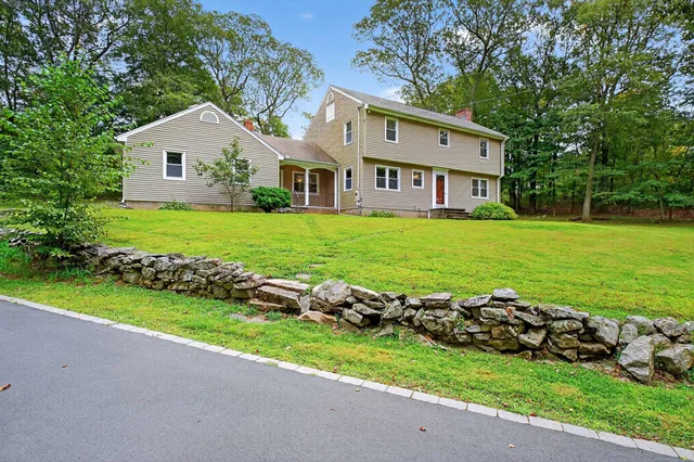 a view of a house with a garden and trees