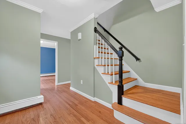 a view of a hallway with wooden floor and staircase