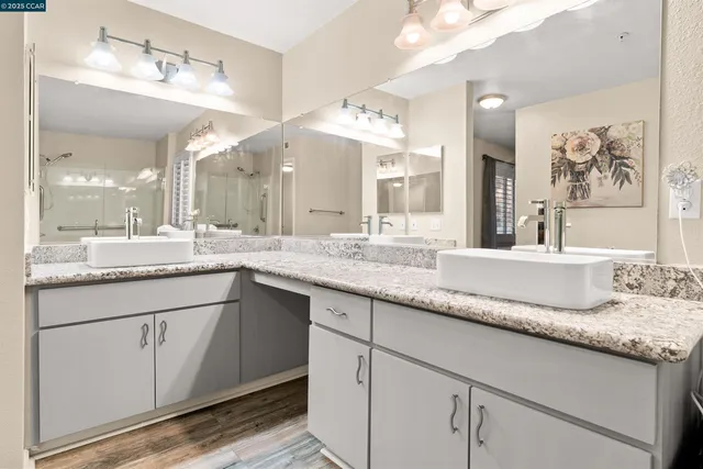 a bathroom with a granite countertop double vanity sink and a mirror