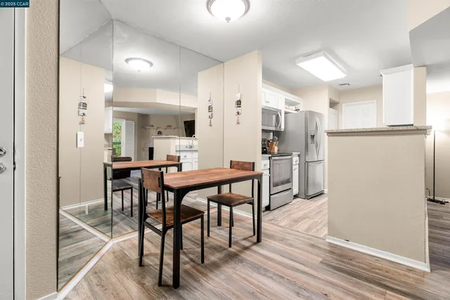 a kitchen with stainless steel appliances wooden floor and dining table