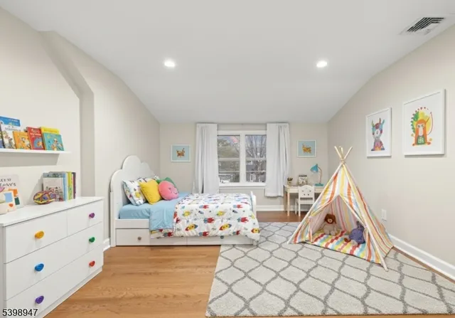a living room with baby crib furniture and a window