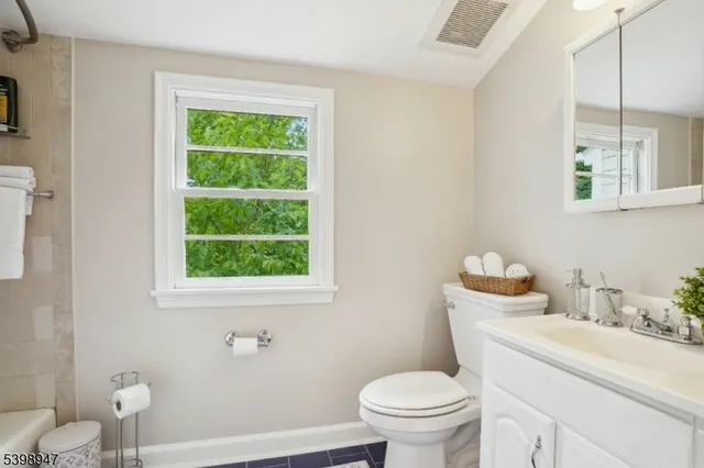 a bathroom with a sink toilet and a window
