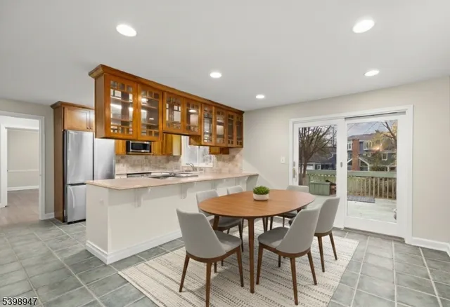 a kitchen with a dining table chairs and refrigerator