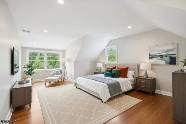 a bedroom with a bed and large windows