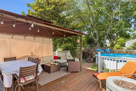 a patio with wooden floor a barbeque grill and outdoor seating