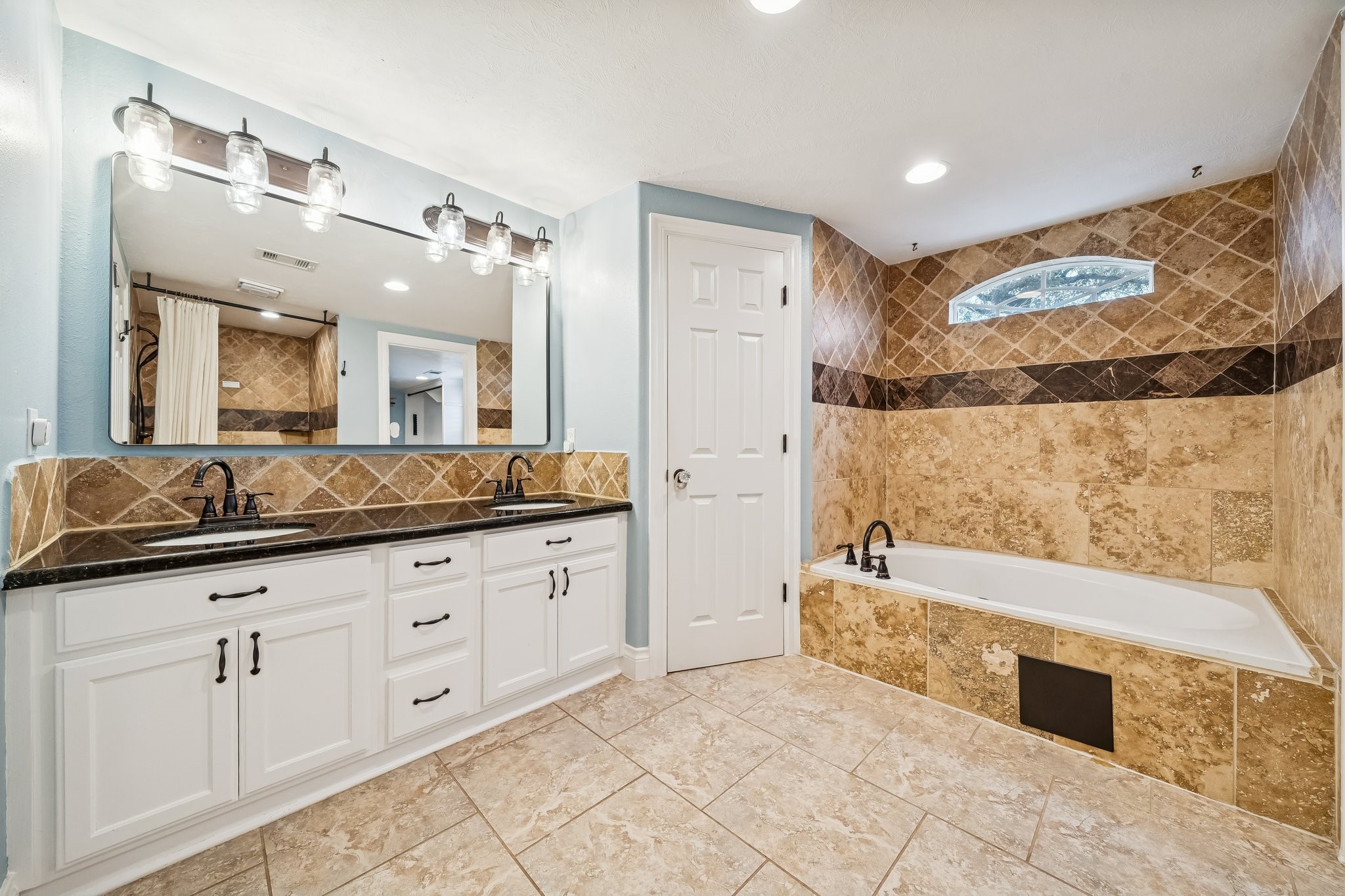 5309 Palmer Street Houston, TX 77004 - Photo 33 of 42 a spacious bathroom with a granite countertop sink a mirror a bathtub and shower