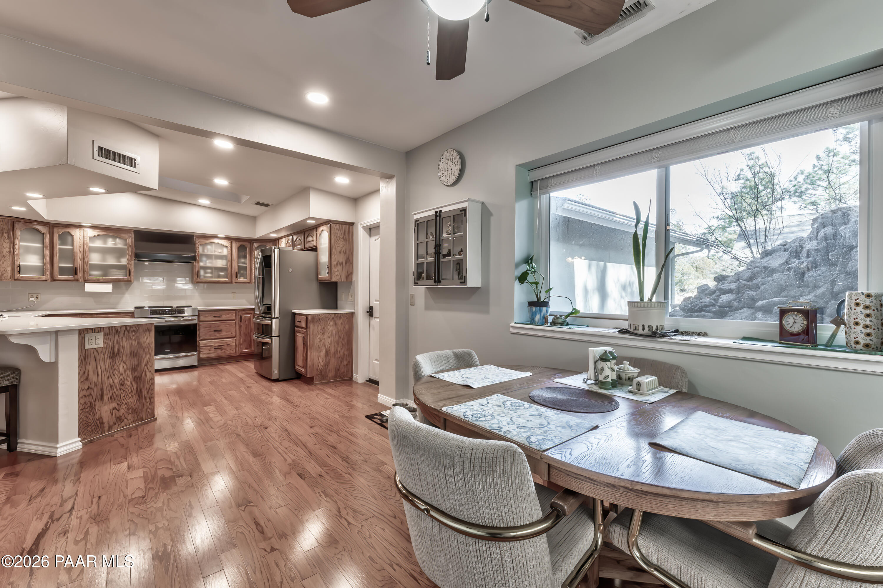 2405 North Williamson Valley Road Prescott, AZ 86305 - Photo 47 of 79 a kitchen with stainless steel appliances kitchen island granite countertop a stove a refrigerator a oven a dining table and chairs with wooden floor