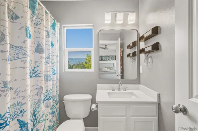 a bathroom with a sink a toilet and a mirror