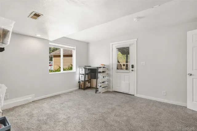 a view of a livingroom with a window and lounge chair