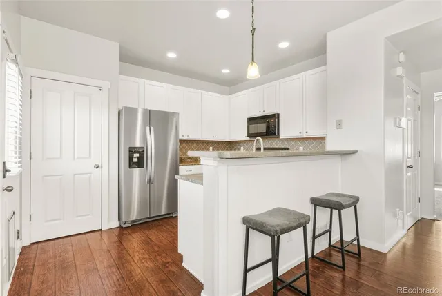 a kitchen with kitchen island white cabinets and stainless steel appliances