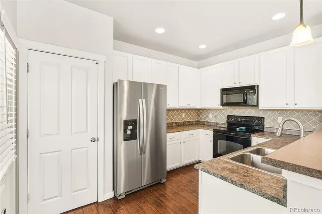 a kitchen with stainless steel appliances granite countertop a refrigerator stove and sink