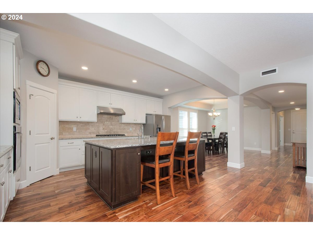 756 North 47th Avenue Ridgefield, WA 98642 - Photo 11 of 42 a kitchen with lots of wooden furniture a sink and a center island