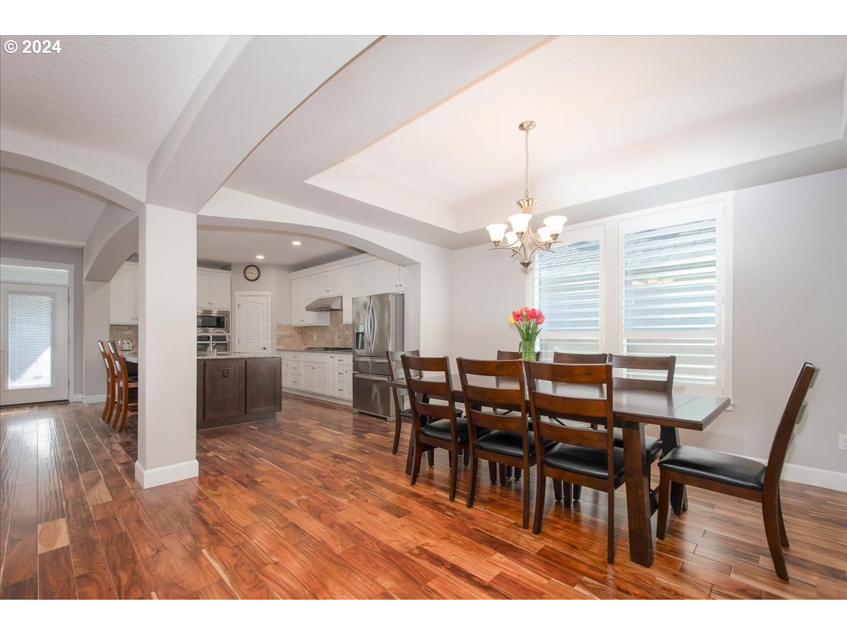 756 North 47th Avenue Ridgefield, WA 98642 - Photo 6 of 42 a dining room filled chandelier and wooden floor