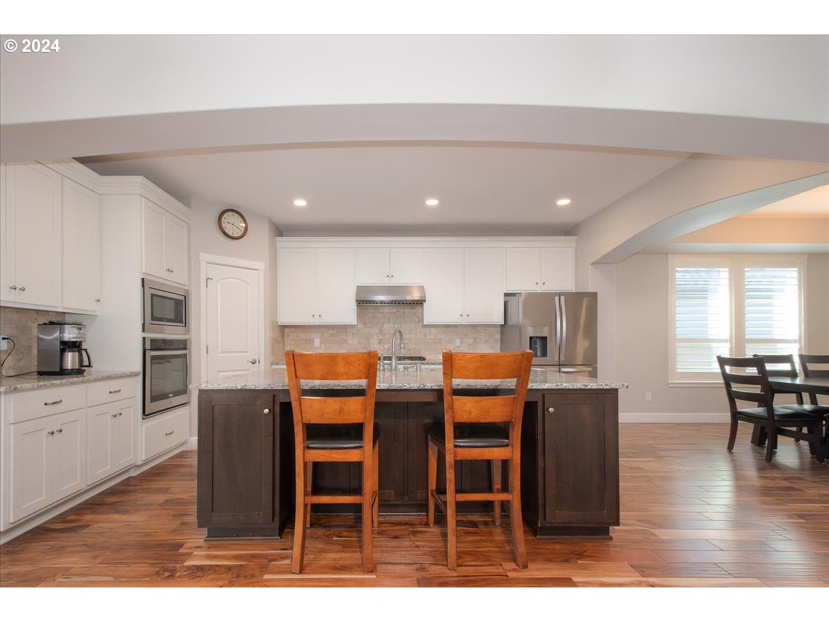 756 North 47th Avenue Ridgefield, WA 98642 - Photo 10 of 42 a dining hall with stainless steel appliances kitchen island granite countertop a dining table chairs and granite counter tops
