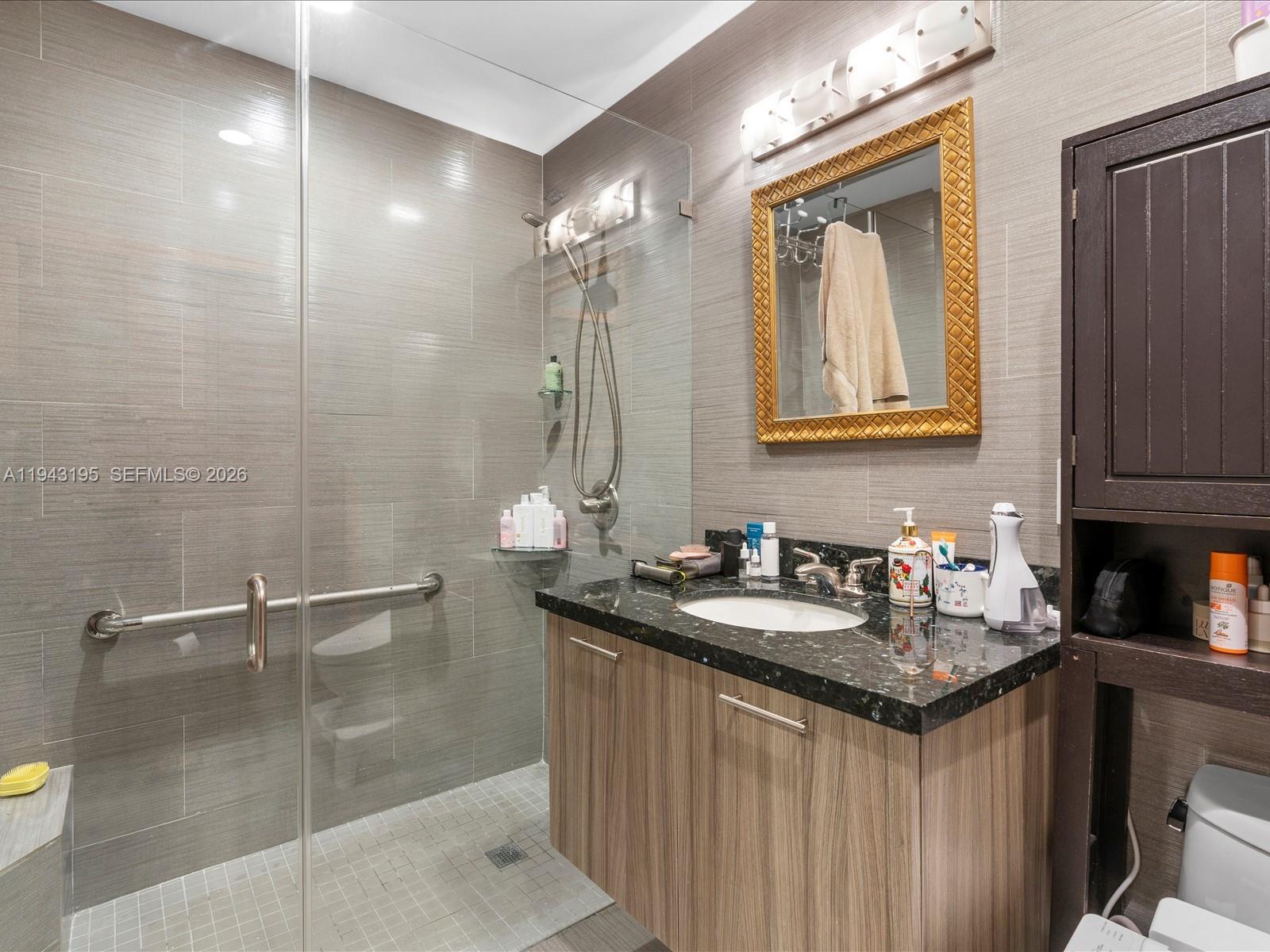 8840 Southwest 50th Terrace Miami, FL 33165 - Photo 13 of 20 a bathroom with a granite countertop sink a mirror and a shower
