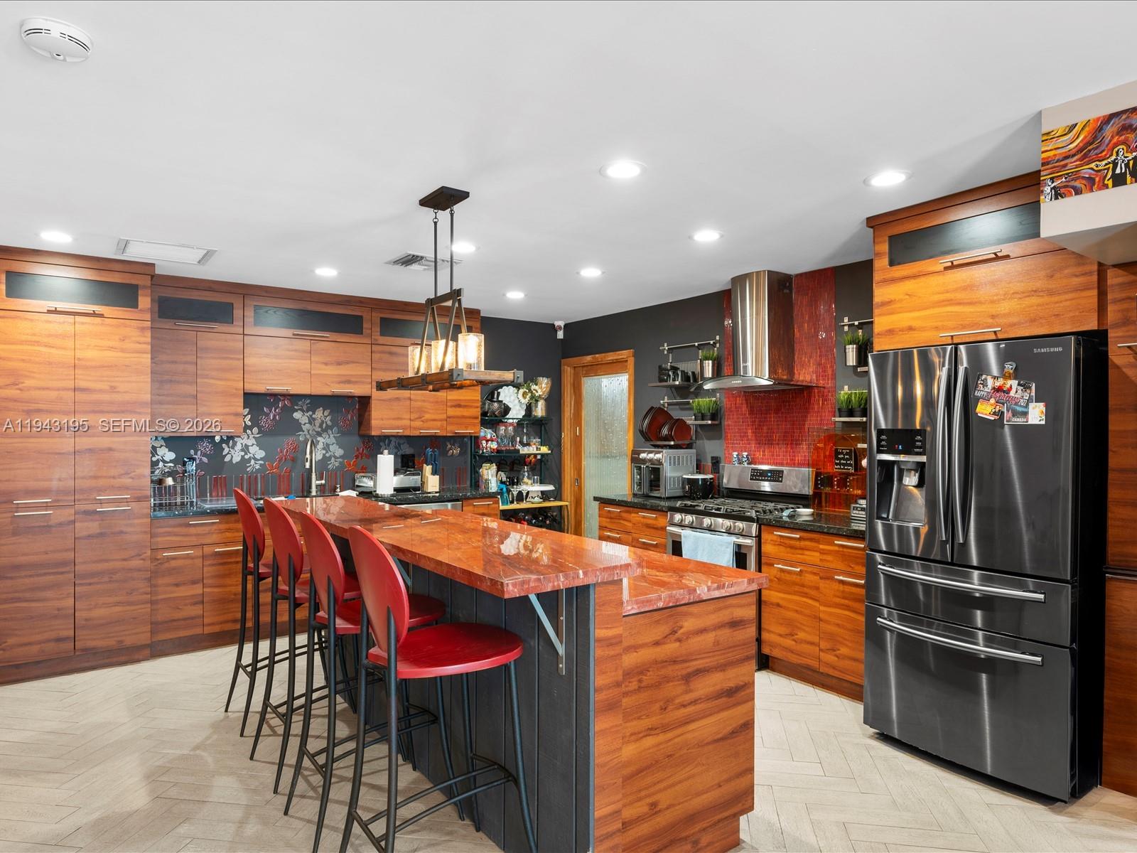 8840 Southwest 50th Terrace Miami, FL 33165 - Photo 4 of 20 a kitchen with stainless steel appliances kitchen island granite countertop a refrigerator a stove top oven a sink with island and chairs