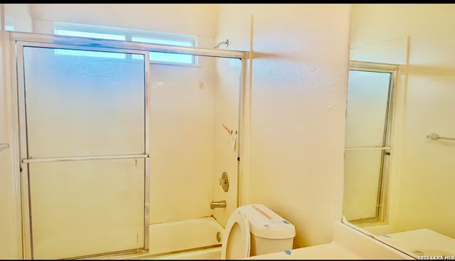 a bathroom with a shower and a glass door