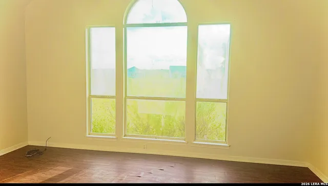 a view of a small space with wooden floor and a window