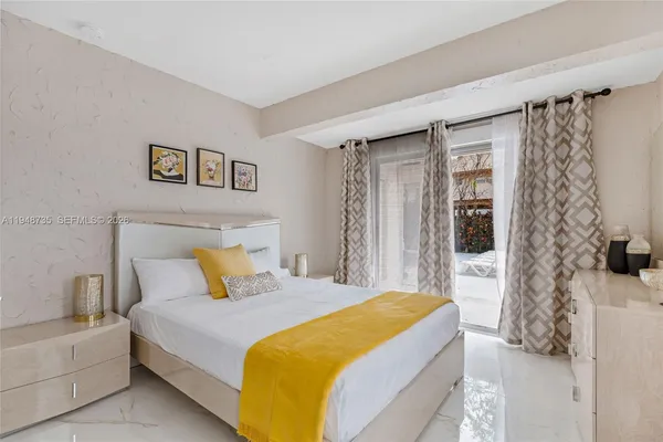 a bedroom with a bed and a lamp on dresser