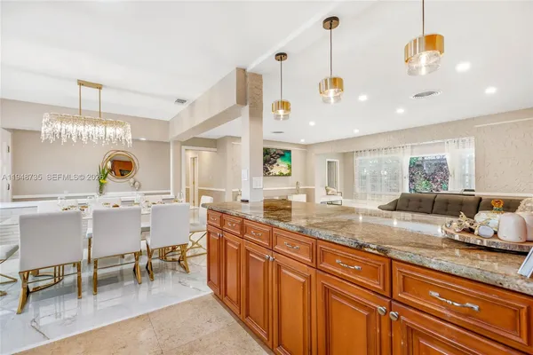 a large kitchen with stainless steel appliances kitchen island granite countertop a sink and cabinets