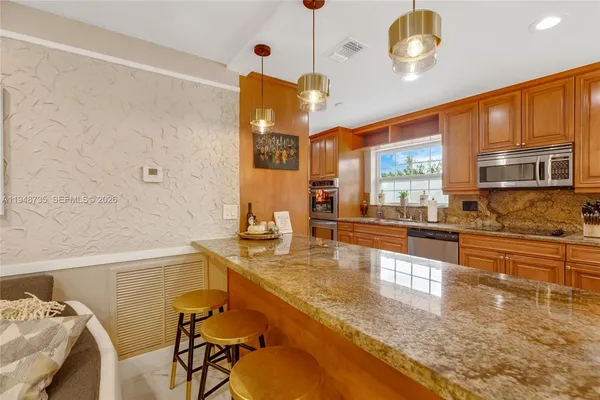 a kitchen with stainless steel appliances granite countertop a refrigerator and a sink