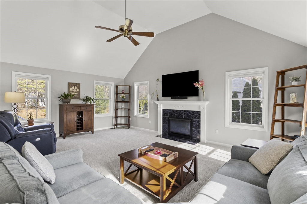 66 Clover Hill Circle Tyngsborough, MA 01879 - Photo 12 of 42 a living room with furniture a fireplace and a flat screen tv