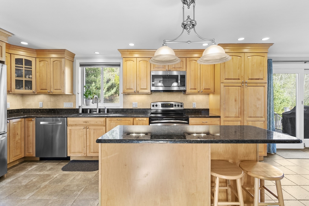 66 Clover Hill Circle Tyngsborough, MA 01879 - Photo 2 of 42 a kitchen with stainless steel appliances granite countertop a sink a stove top oven a counter space and cabinets