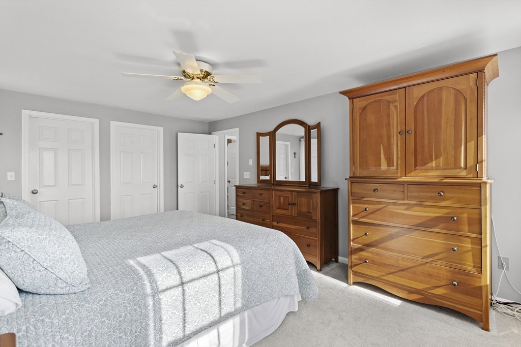 66 Clover Hill Circle Tyngsborough, MA 01879 - Photo 23 of 42 a bedroom with a bed and a chandelier