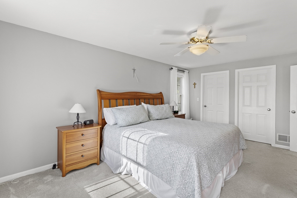 66 Clover Hill Circle Tyngsborough, MA 01879 - Photo 24 of 42 a bedroom with a bed and a chandelier