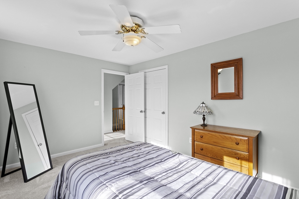 66 Clover Hill Circle Tyngsborough, MA 01879 - Photo 27 of 42 a bedroom with a bed and a chandelier
