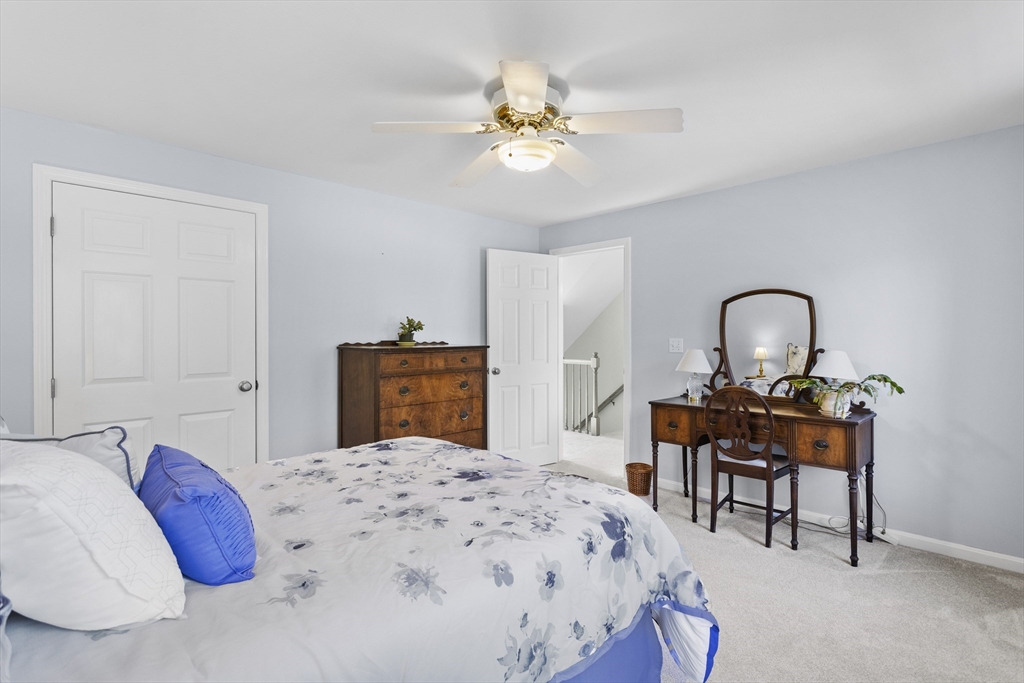 66 Clover Hill Circle Tyngsborough, MA 01879 - Photo 29 of 42 a bedroom with a bed and a chandelier