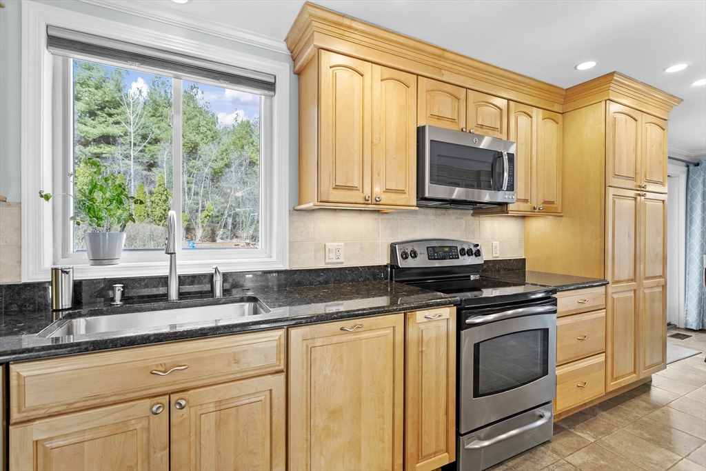 66 Clover Hill Circle Tyngsborough, MA 01879 - Photo 5 of 42 a kitchen with granite countertop a sink cabinets stainless steel appliances and a window