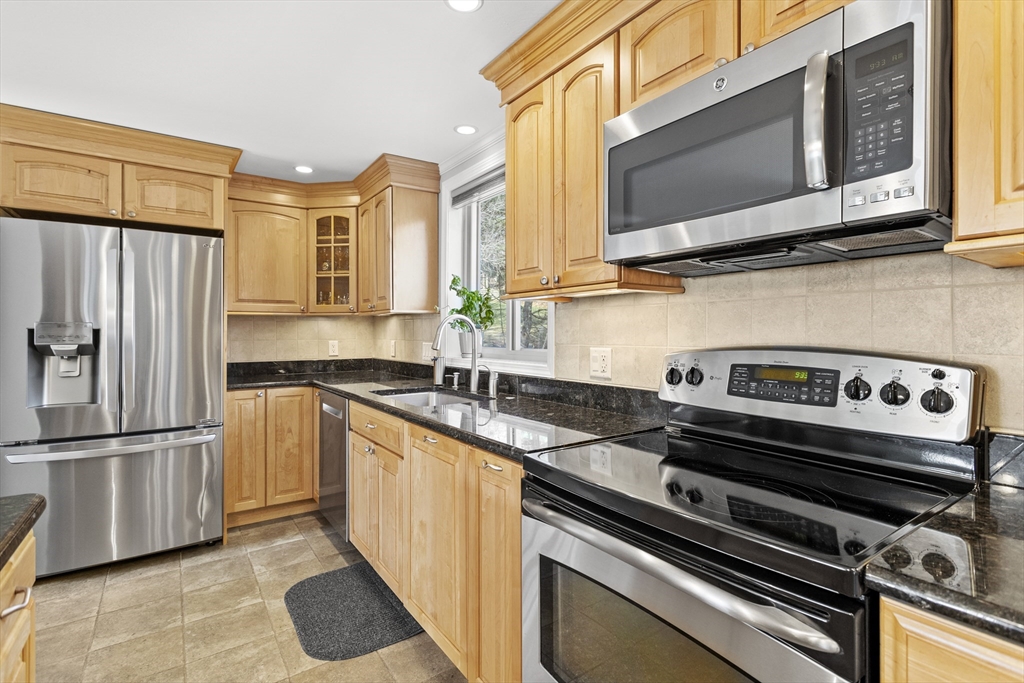 66 Clover Hill Circle Tyngsborough, MA 01879 - Photo 6 of 42 a kitchen with stainless steel appliances granite countertop a stove microwave and refrigerator