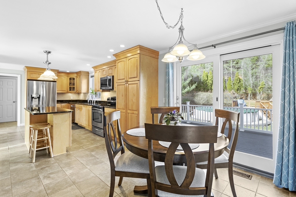66 Clover Hill Circle Tyngsborough, MA 01879 - Photo 7 of 42 a dining room with furniture a chandelier and wooden floor