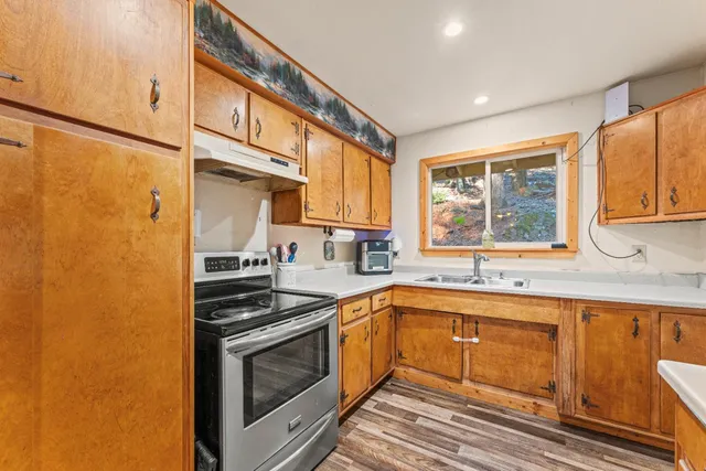 a kitchen with stainless steel appliances a sink stove and cabinets
