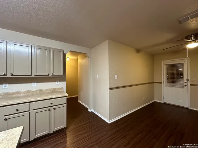 an empty room with wooden floor and cabinets