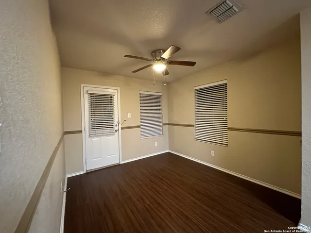 a view of a livingroom with wooden floor and a ceiling fan