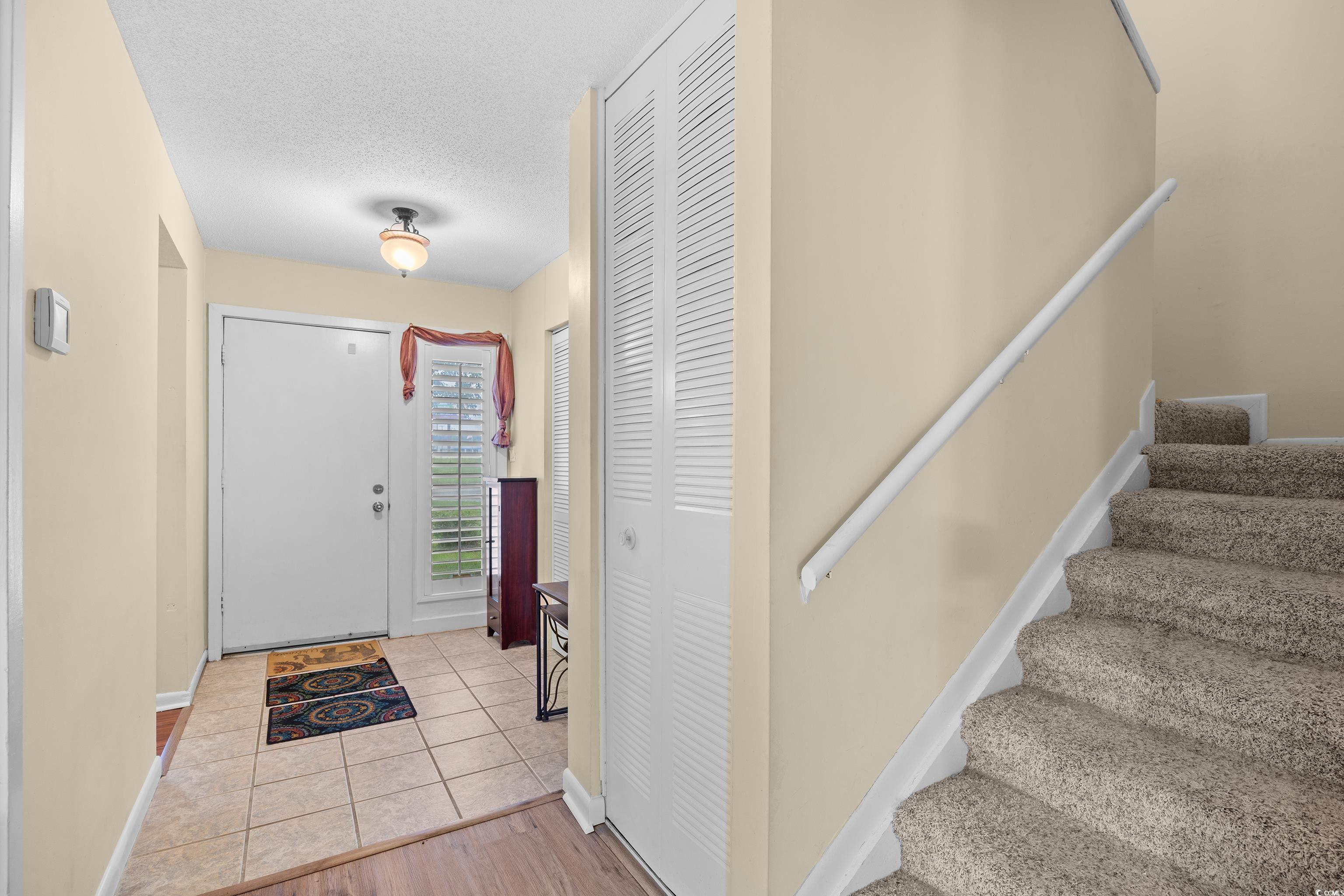 500 Eagle Way, Unit 4 Little River, SC 29566 - Photo 6 of 19 Foyer with a textured ceiling, stairway, and light tile patterned floors