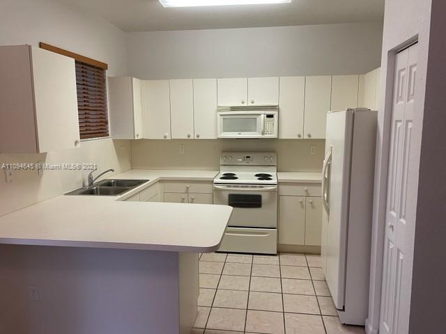 Oasis Homestead, FL 33033 - Photo 9 of 37 a kitchen with a sink a stove and refrigerator