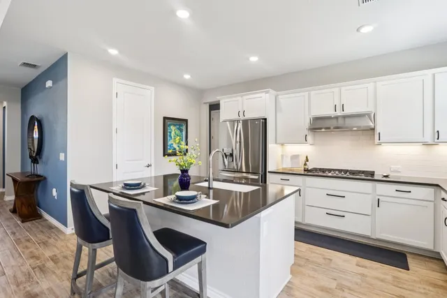 a kitchen with kitchen island granite countertop a sink counter top space and stainless steel appliances