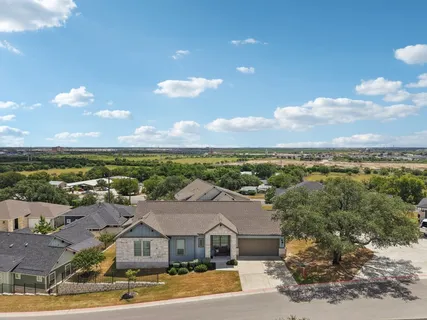 an aerial view of residential houses with outdoor space and ocean view