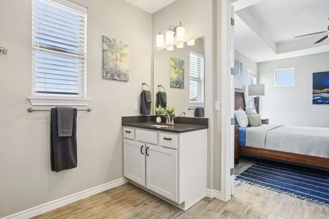 a bathroom with a granite countertop shower a sink and a mirror
