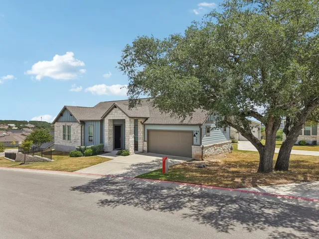 a front view of a house with a yard and trees