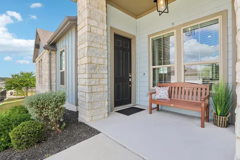 a view of a deck with a bench and floor to ceiling window