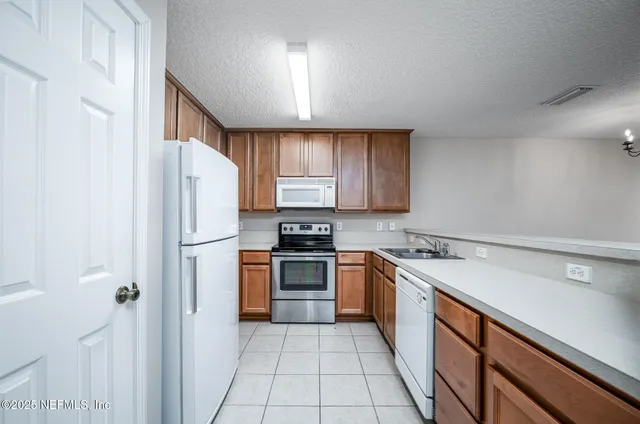 a kitchen with stainless steel appliances granite countertop a refrigerator sink and stove
