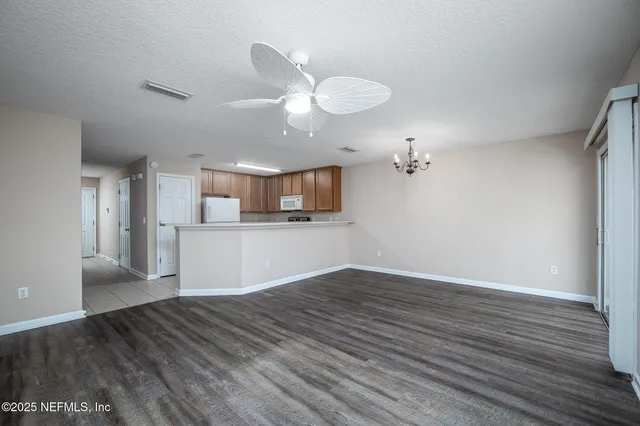 a view of a kitchen with wooden floor and a ceiling fan