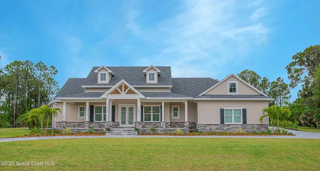 a front view of house with yard space and trees in the background