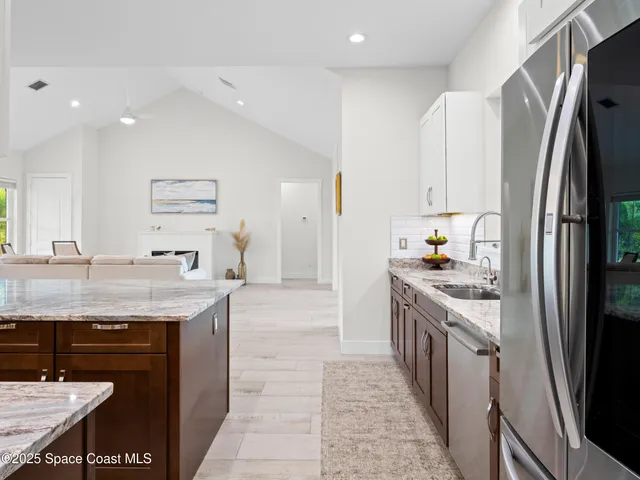 a kitchen with granite countertop a stove a sink dishwasher and cabinets with wooden floor